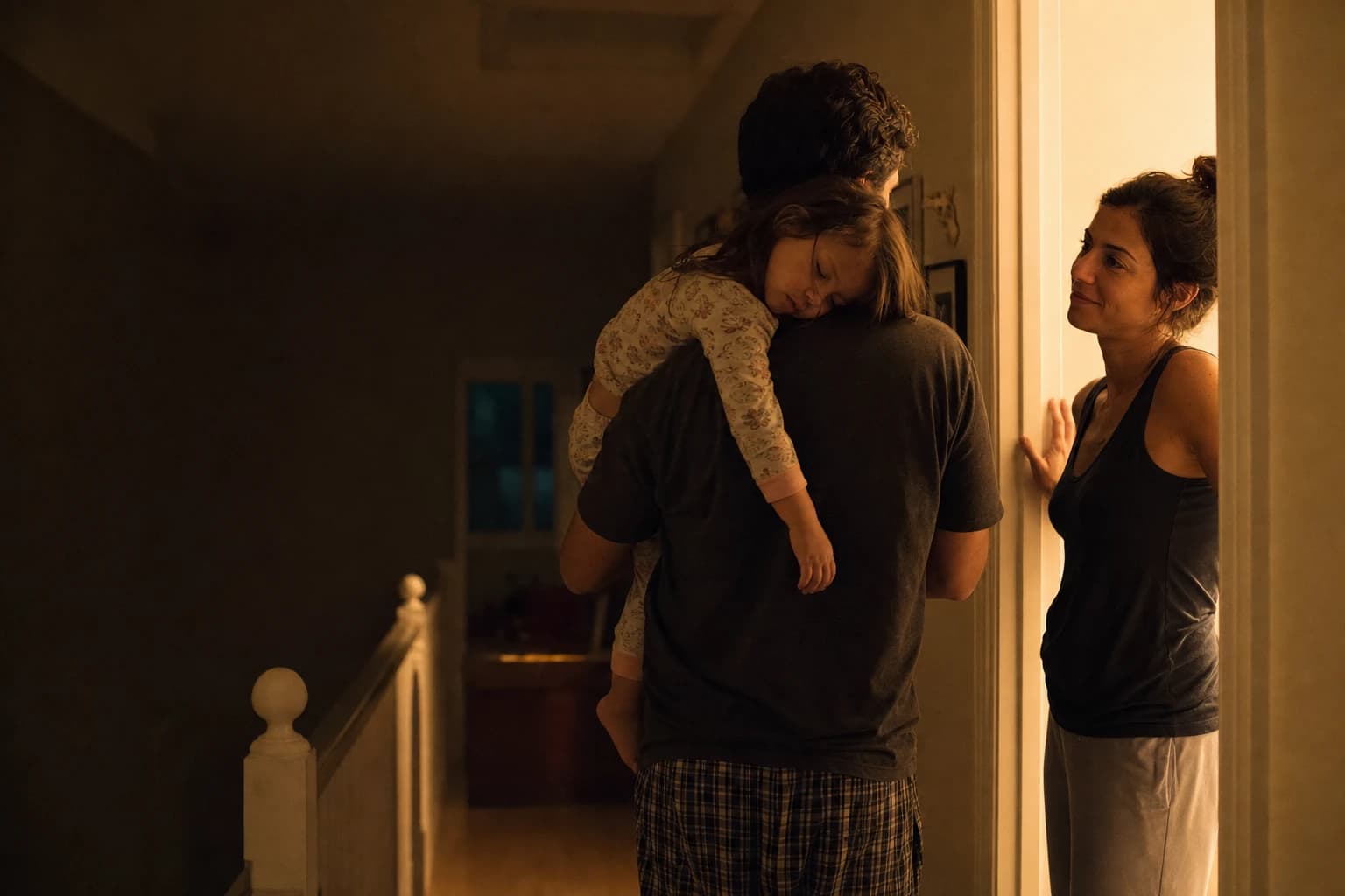 A father carries his sleeping daughter to bed in the evening